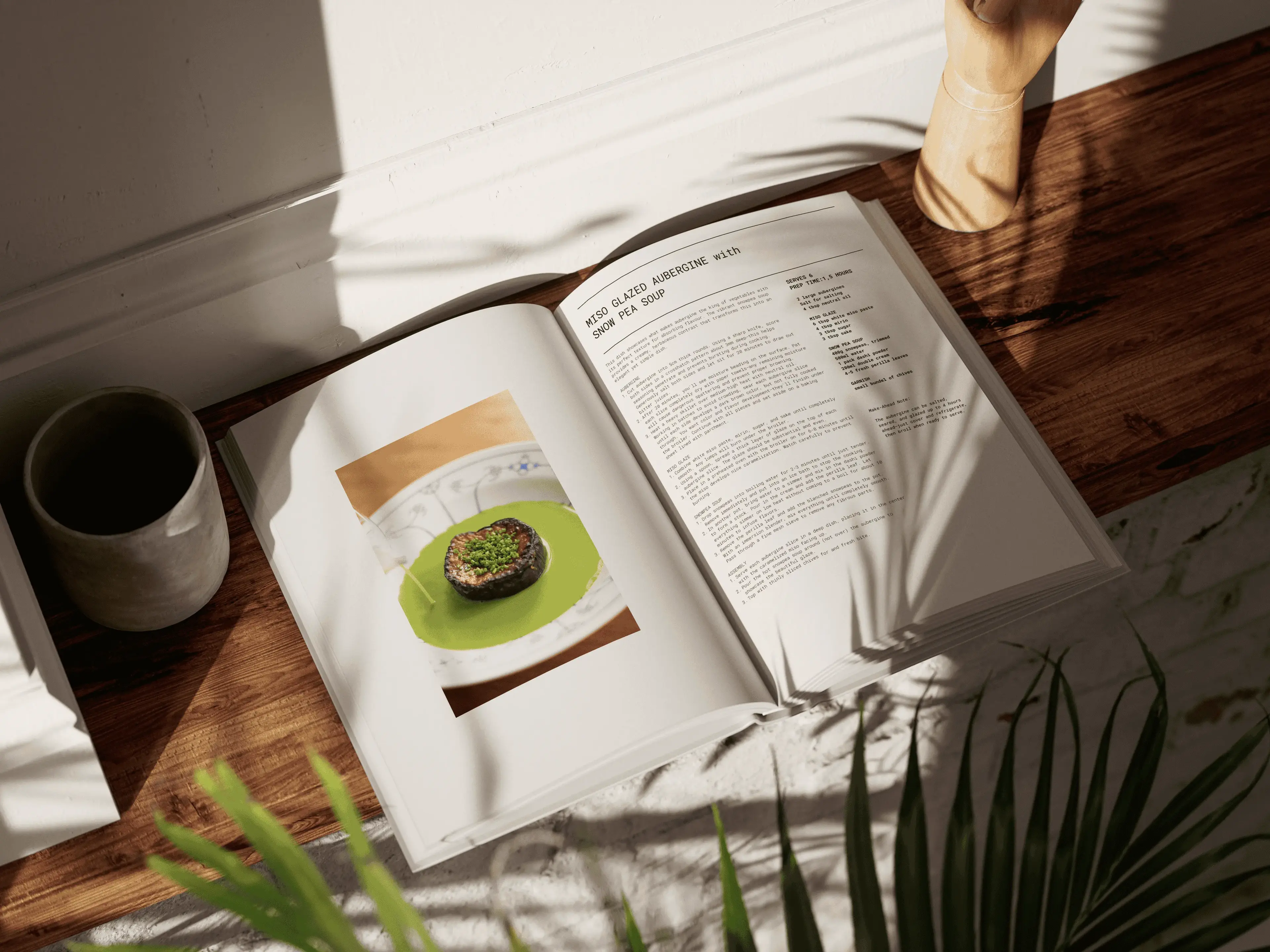 Open cookbook on a wooden surface with a recipe and a photo of a dish. Sunlight and shadows from plants create a cozy atmosphere.